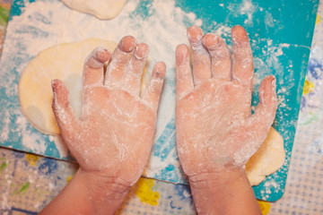 child's hands stained with flour