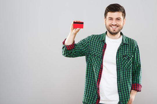 Smiling man holding red credit card