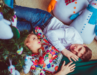 The lovely couple in love lie near Christmas Tree