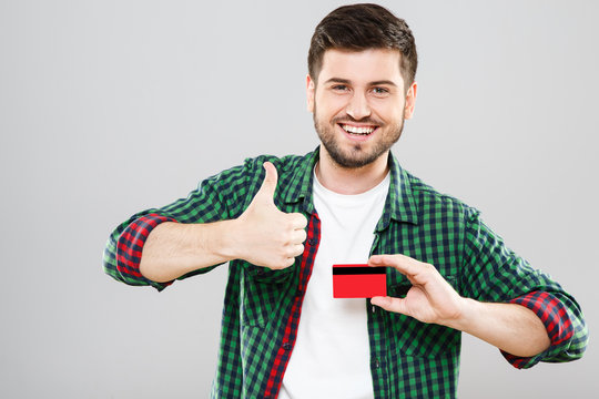Man holding credit card and showing thumbs up