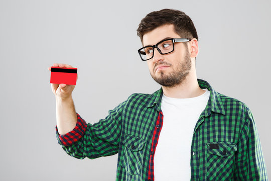 Man in eyeglasses holding red credit card