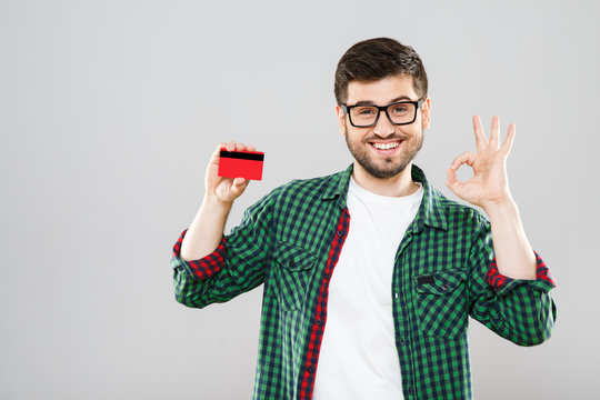 Man holding red credit card and showing ok