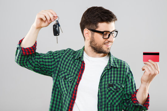 Man holding car keys and credit card