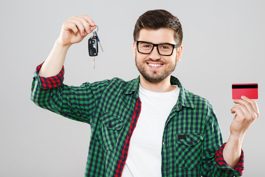 Man holding car keys and red credit card