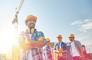 group of smiling builders in hardhats outdoors