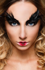 Fototapeta premium Young pretty woman face with false feather eyelashes fashion makeup