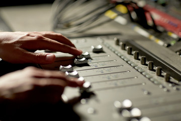 Fototapeta premium hands on mixing console in music recording studio