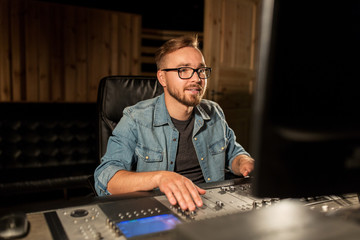 man at mixing console in music recording studio