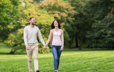 happy couple walking in summer park