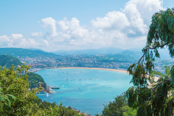 Naklejka premium seascape with blue water, boats and the city. San Sebastian Basque Country. Ocean color image