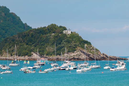 Fototapeta seascape of bay with blue water and yachts on the background of the city. 