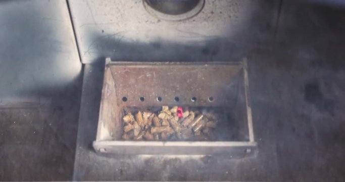 Video of the combustion chamber of a pellet stove with the pellets being ignited and filling with smoke.