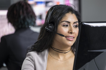 Young hispanic customer service representative talking on a headset