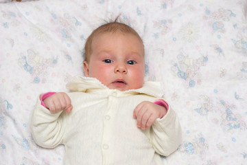 Малыш в белой кофте с согнутыми руками