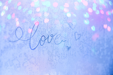 Love - a beautiful inscription on the frosty glass