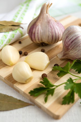 Fresh garlic, onion and spices on a light background closeup