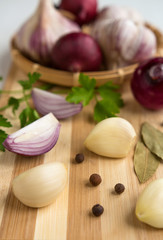 Fresh garlic, onion and spices on a light background closeup
