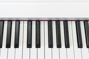 Classical piano with red decorative strip at the base of keys, close-up