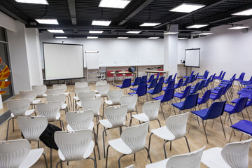 Empty light business room with lot of white and blue chairs is ready for conference or seminar