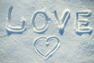 The word love and a heart drawn in the snow.