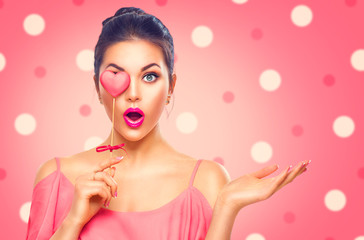 Valentine's Day. Beauty surprised young fashion model girl with Valentine heart shaped cookie