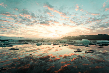 Reflection of cloudy sky in sea at sunset