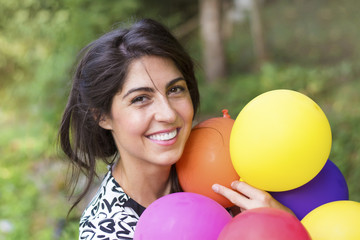 Fototapeta na wymiar Young pretty woman holding colored balloons