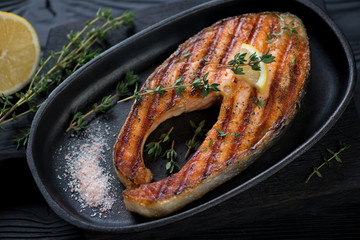 Close-up of barbecued salmon steak served in a cast-iron pan