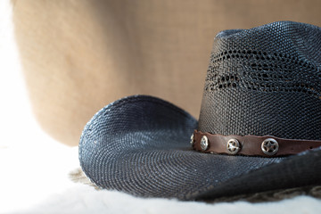 detail of black cowboy hat with beige background
