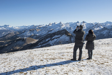 Wanderer auf dem Fronalpstock fotografieren die gegenüberliegende Bergkette, Schwyz, Schweiz