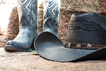 detail of black cowboy hat with blue boots