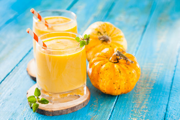 pumpkin smoothie in a glass on a table, selective focus, copy space