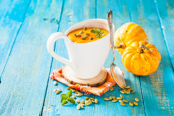 pumpkin cream soup in a cup on a table, selective focus, copy space