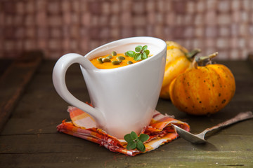 pumpkin cream soup in a cup on a table, selective focus, copy space