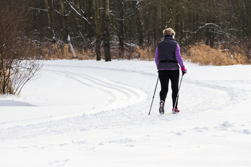 Kobieta uprawiająca nordic walking w parku zimą na śniegu © marcar1976