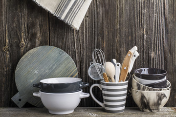 Cookware in gray and tools on a wooden kitchen shelf in the background rustic  wall. The horizontal design