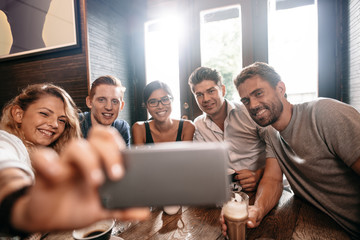 Fototapeta premium Diverse group of friends taking selfie at cafe