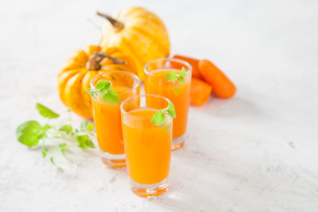 carrot and pumpkin juice and ingredients on a light background, selective focus, copy space