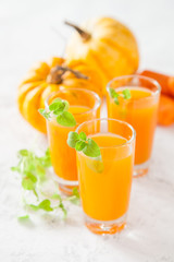 carrot and pumpkin juice and ingredients on a light background, selective focus, copy space