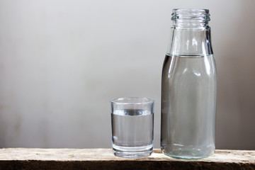 Drinking water in glass and bottle on a wooden floor.