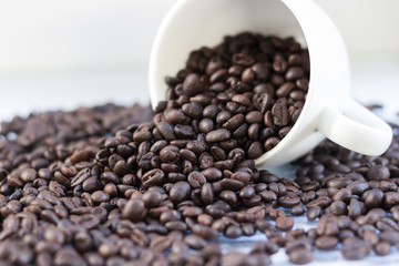 Coffee beans in coffee cup isolated on white