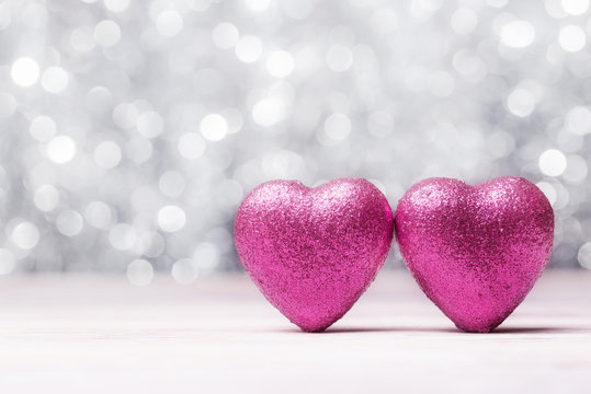 Two pink Valentines hearts over white abstract lights