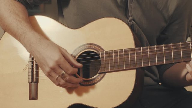 Hands of guitarist playing a guitar