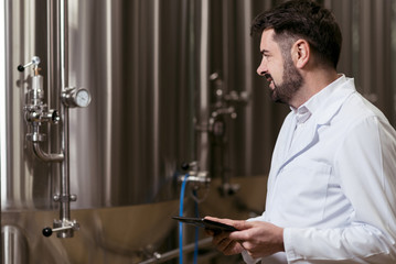 Concentrated man standing in brewery