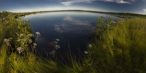 Fototapeta na wymiar Panorama of forest lake in calm weather.