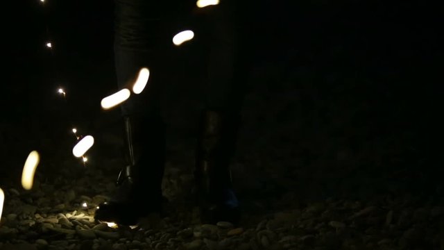 Ragazza giovane che gioca con le luci led di notte sulla spiaggia vicino al mare