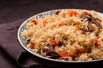 Pilaf on plate with oriental ornament. Central-Asian cuisine - Plov.