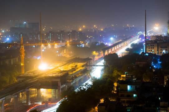 Construction of the Delhi metro Noida extension at night. The traffic flow is only lighly disturbed while the construction progresses