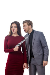 girl in a red dress pulling man by tie