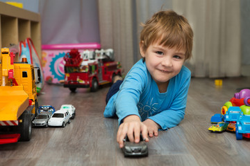 little boy plays with toy car at home